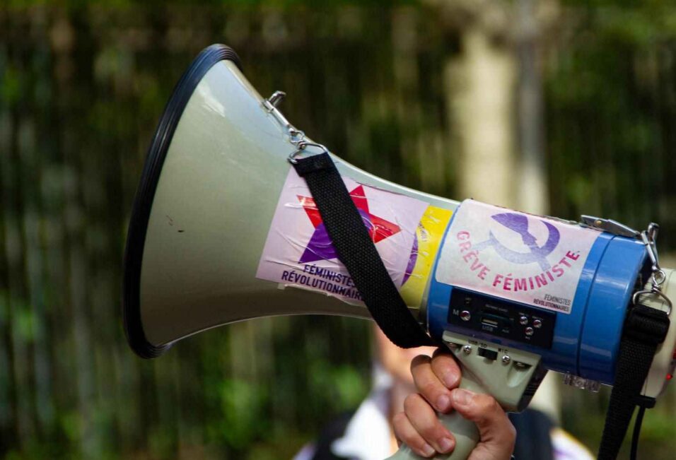 Un mégaphone avec des autocollants "Féministes révolutionnaires" et "grève féministe"